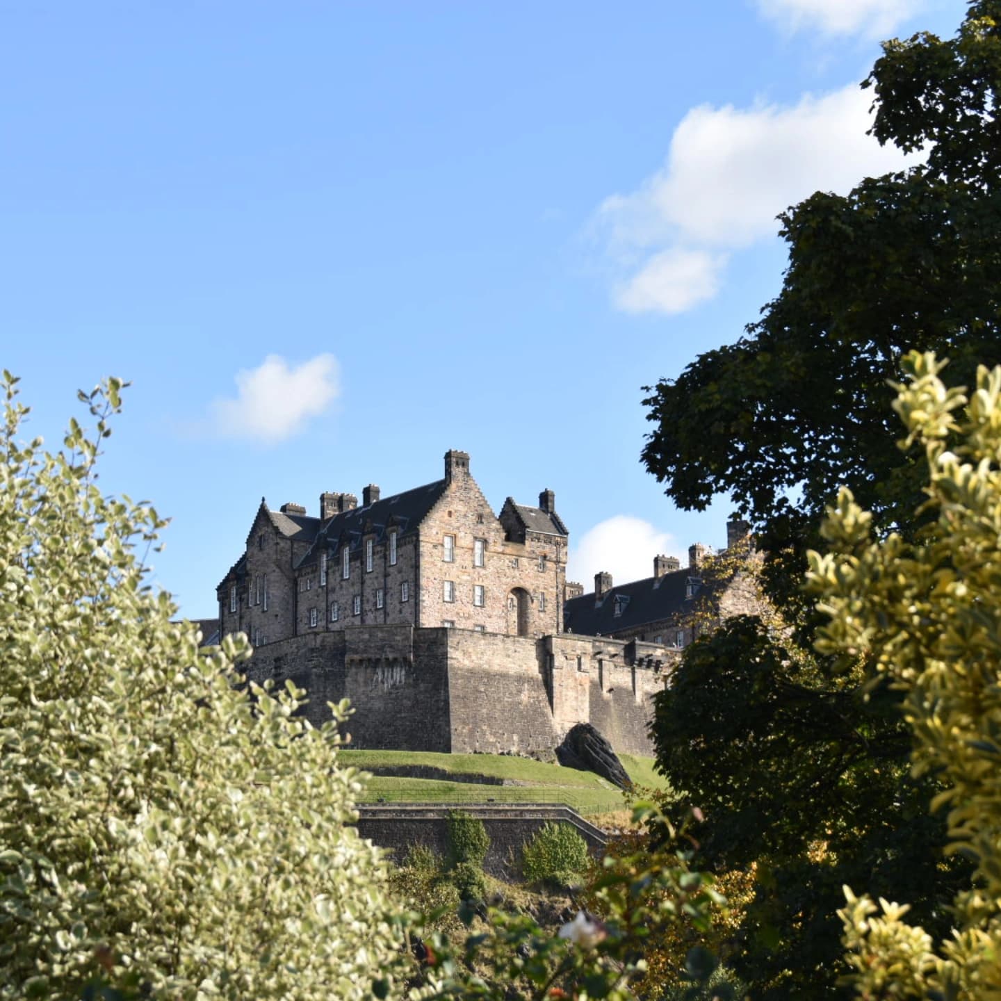 Edinburgh Castle perched on Castle Rock above West Princes Street Gardens